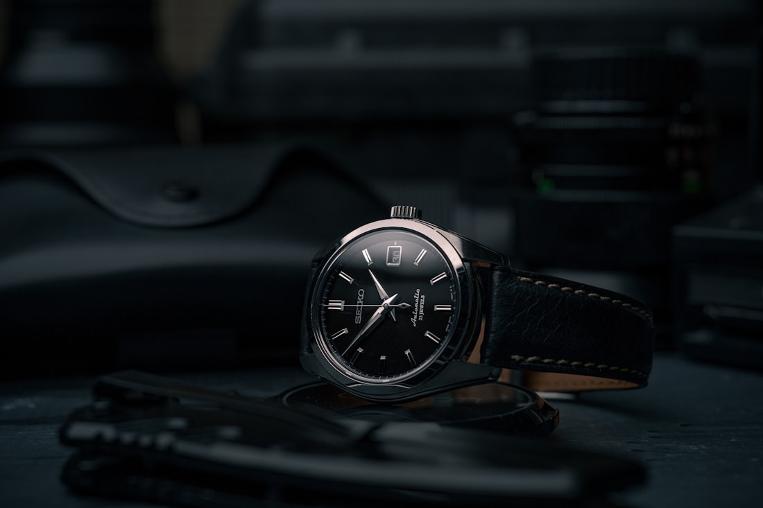 black and silver round analog watch