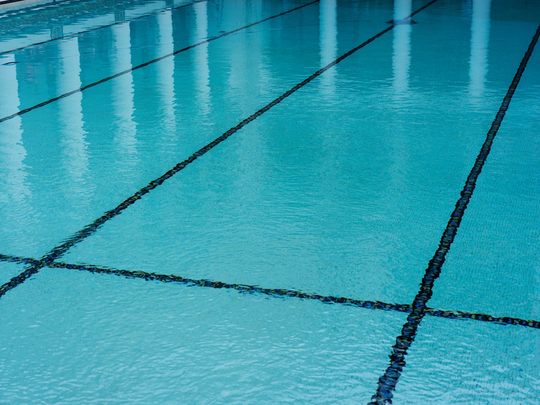 A swimming pool with a tiled floor and blue water