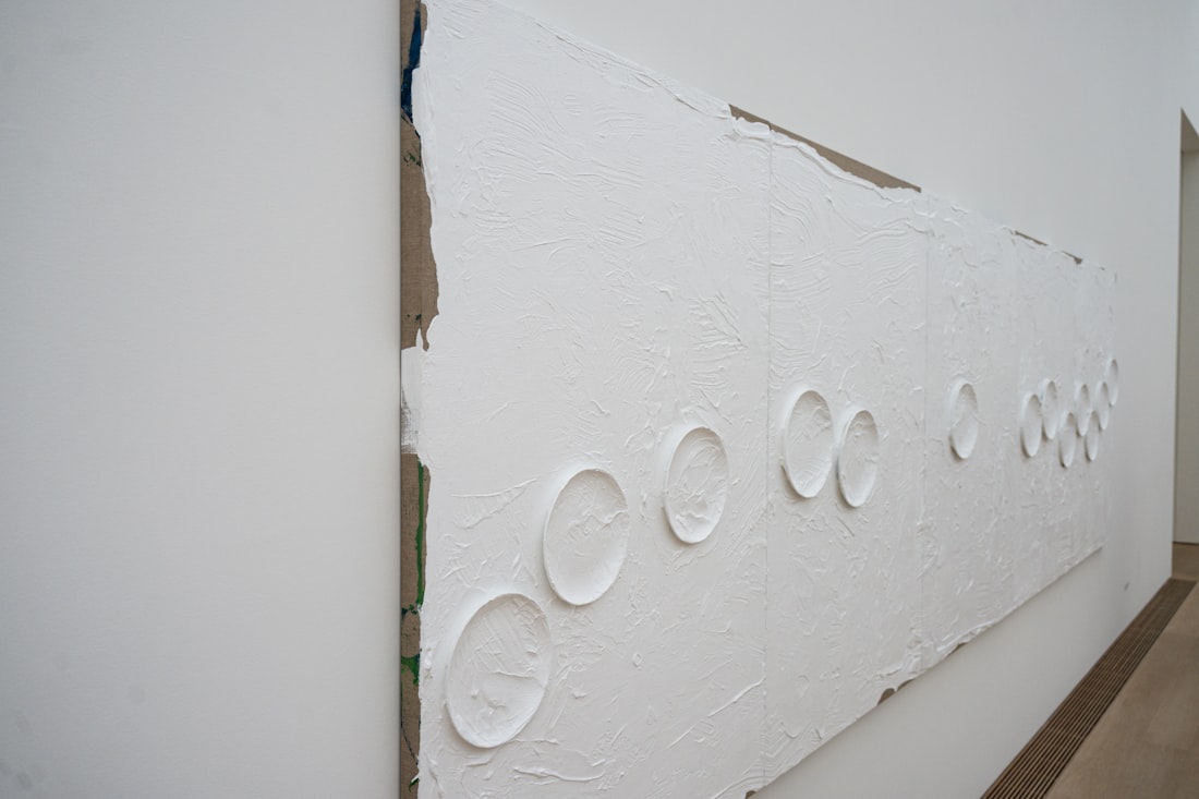 Textured white wall featuring a row of raised circular patterns.